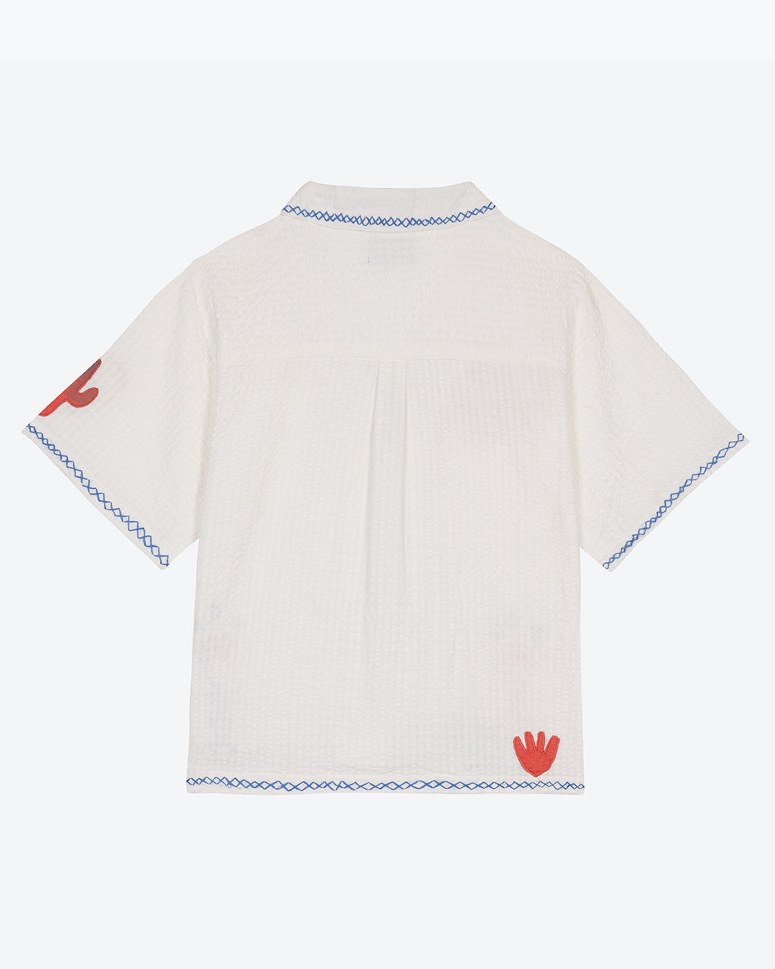 A white cotton blouse with colorful hand embroidery details, featuring a notched collar, wide cut sleeves, and a boxy fit.