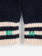 Close-up of navy and beige striped gloves with 'BC' logo on a white background