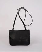 Black leather shoulder bag on a light gray background