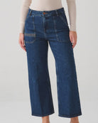 Person wearing blue jeans on a plain background