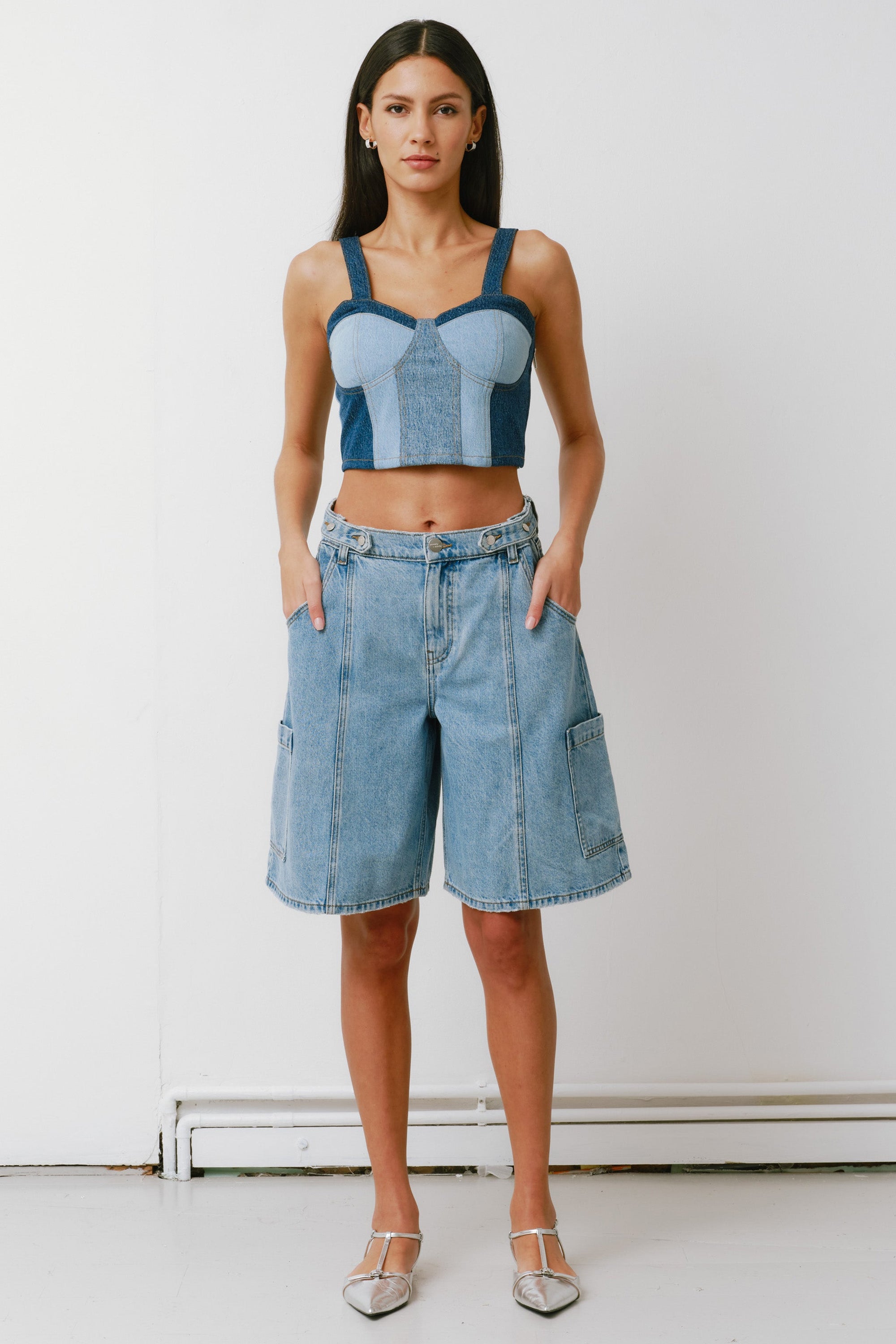 Woman wearing a denim crop top and shorts against a white background