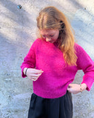 Person wearing bright pink mohair jumper 