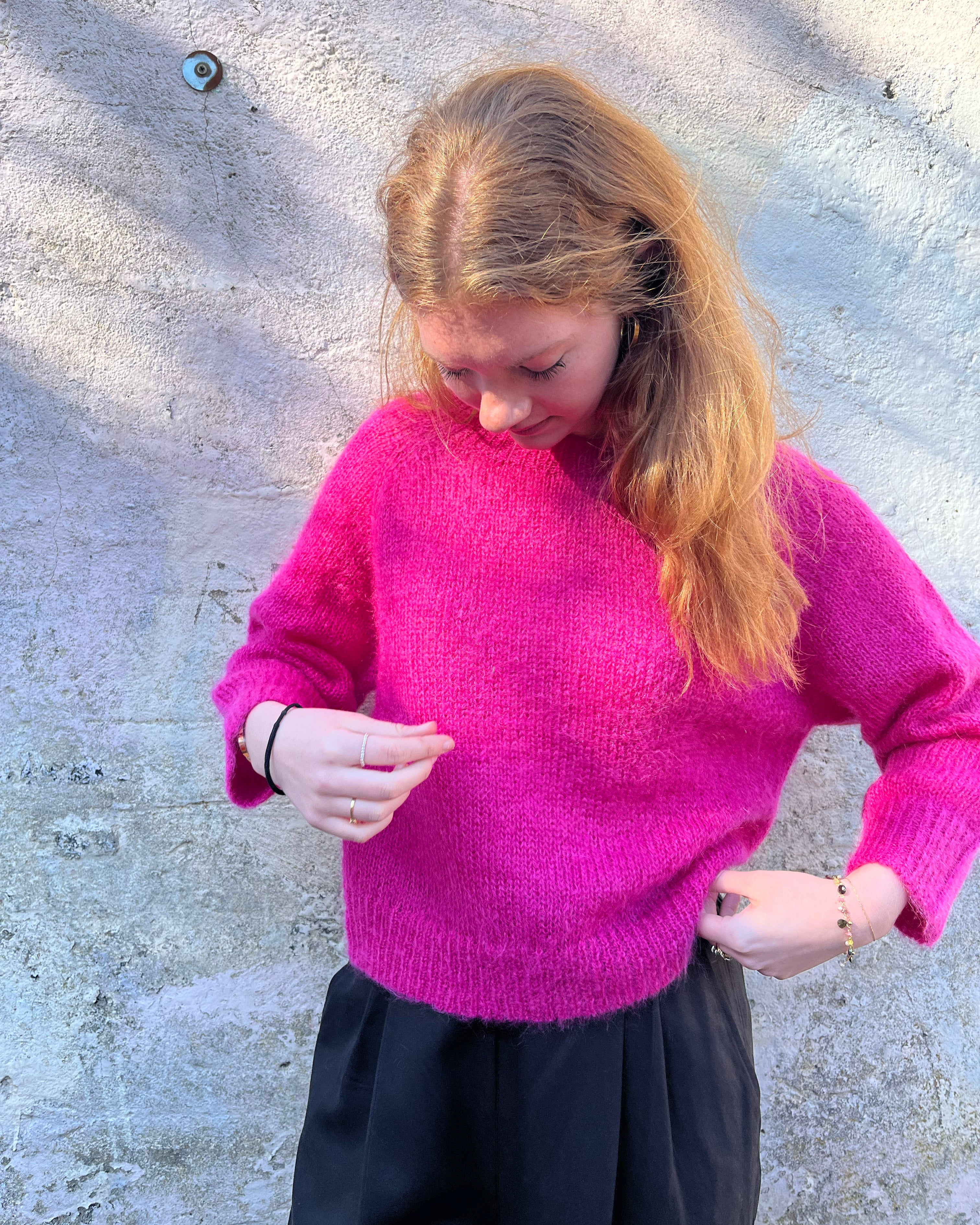 Person wearing bright pink mohair jumper 