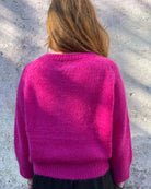 Person wearing bright pink mohair jumper 