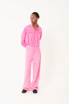 Person wearing a pink jumpsuit on a white background