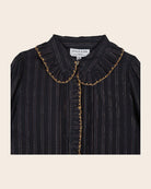Black pinstripe blouse with gold trim on a beige background