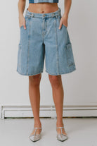 Person wearing blue denim shorts on a plain background