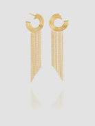 Gold hoop earrings with chain tassels on a light gray background