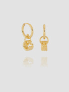 Gold hoop earrings with key-shaped charms on a light gray background