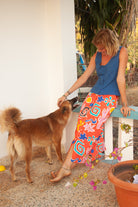 A midi-length orange skirt with a colorful abstract print, featuring side pockets and elasticated back waist.
