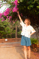 Woman reaching up to touch pink flowers in a garden setting