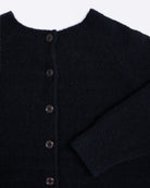 Close-up of a dark blue cardigan with buttons on a white background