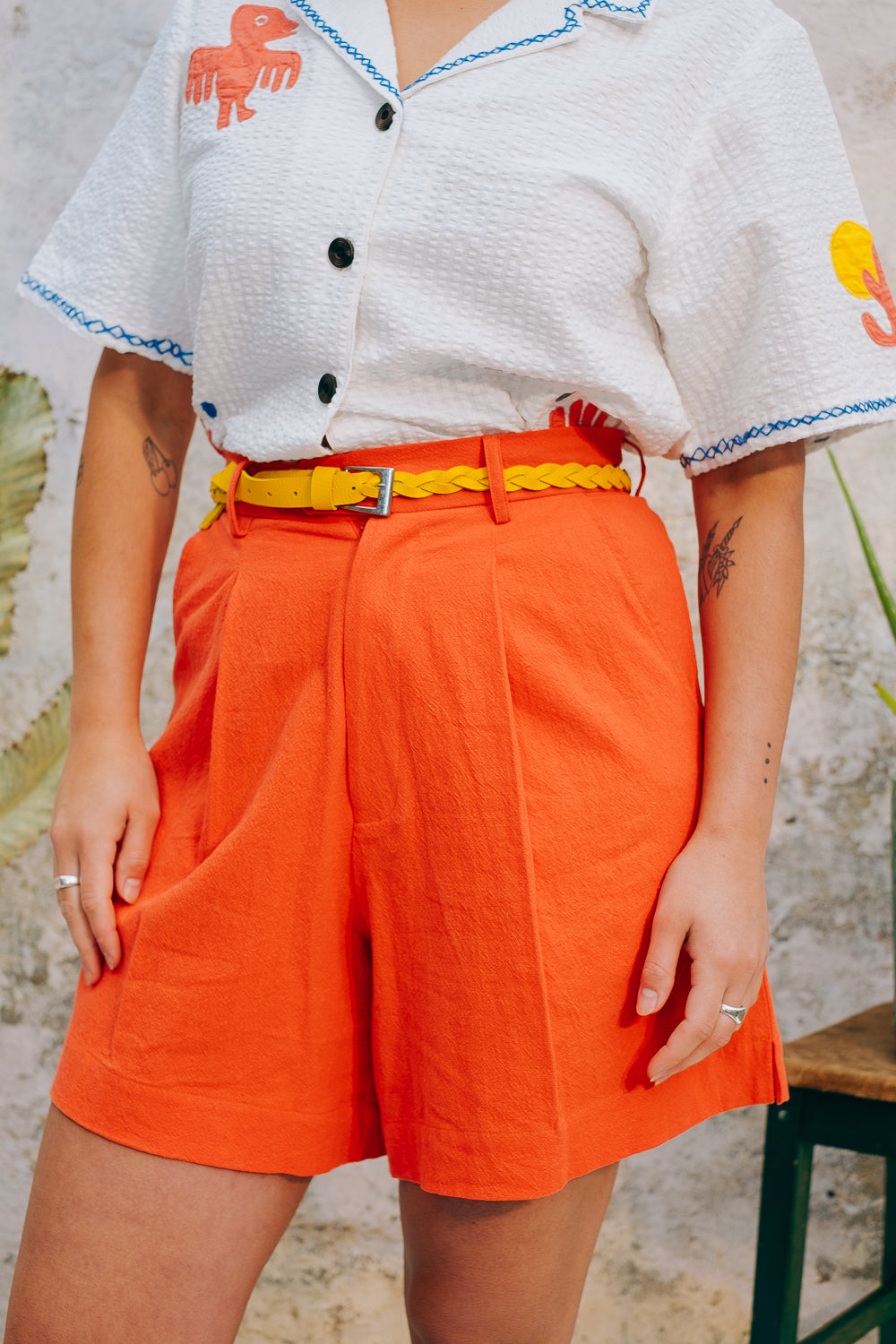 A pair of high-waisted, mid-length, tailored tomato shorts made from a cotton and linen mix.