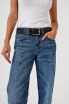 A pair of blue denim jeans with a frayed hem and a deep turn-up at the cuffs, featuring a straight leg cut and mid-rise waist.
