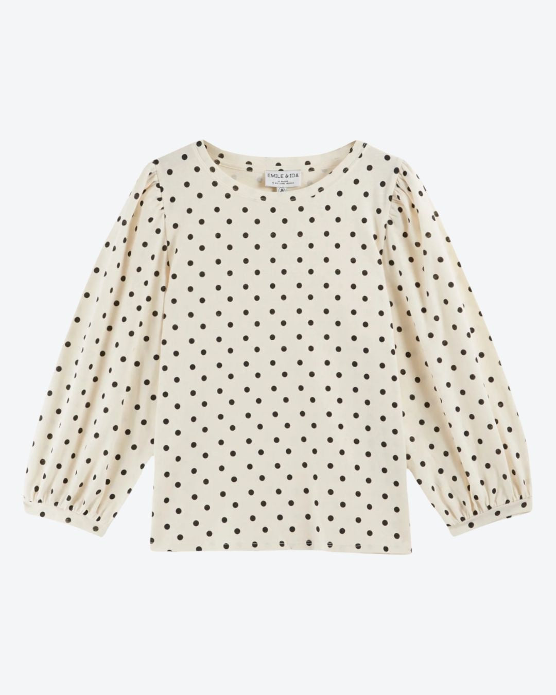 Beige long-sleeve top with black polka dot pattern on a white background
