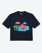 A navy blue t-shirt with a graphic print of a lake scene at dusk with a lone canoe, pink and blue waters, and green trees.