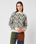 Person wearing a patterned sweater with a plain background