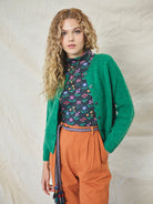 A pair of orange wide leg trousers with pleats and a fixed turn-up hem, made from cotton drill fabric.