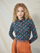 A long sleeve printed roll neck t-shirt with a turtle pattern in multicolor on a black background, made from organic cotton.