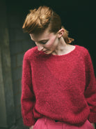 A cropped, bracelet sleeve, round neck red mohair jumper.
