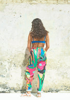 A pair of Miss Pompom Jungle Holiday Trousers with a vibrant hand-drawn tropical print in bright colors.