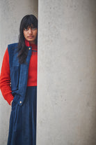 Person Lowie denim stripe gilet against a gray wall