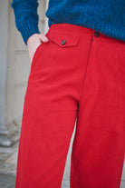 Red pants with a blue sweater worn by a person, blurred background