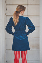 woman wearing a short navy corduroy dress 