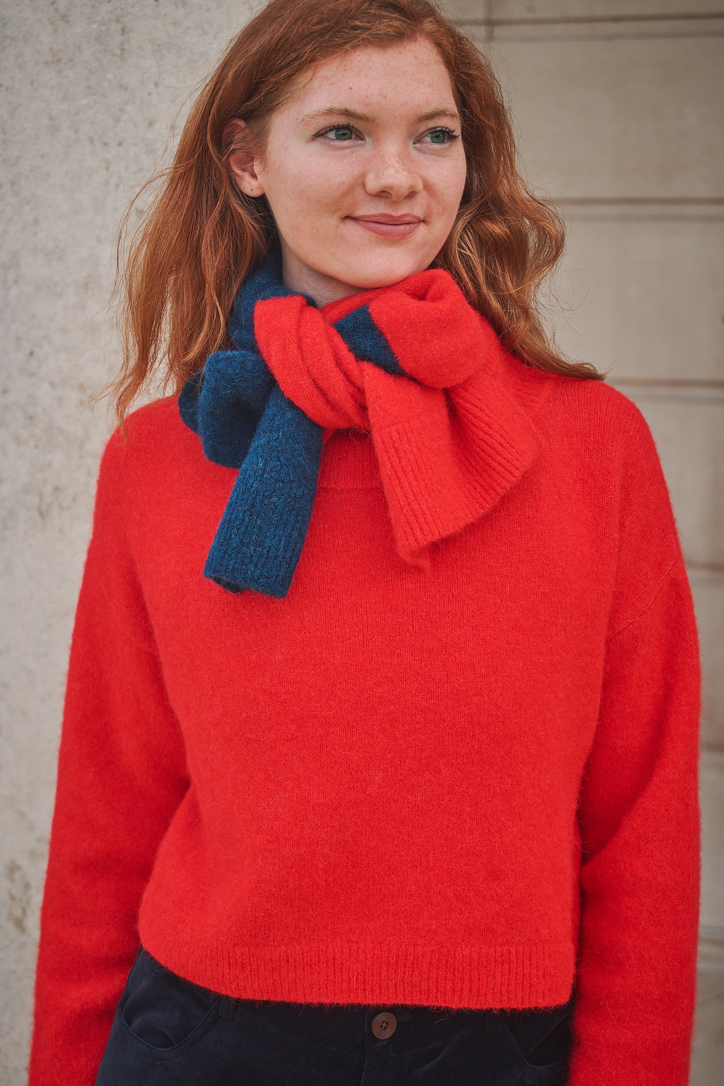 Woman wearing a striped Red/ Blue scarf