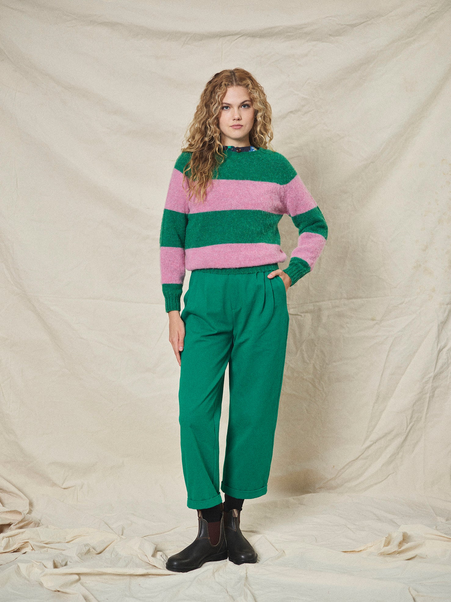 A pair of green pleat front trousers with a tab front opening and back jet pockets.