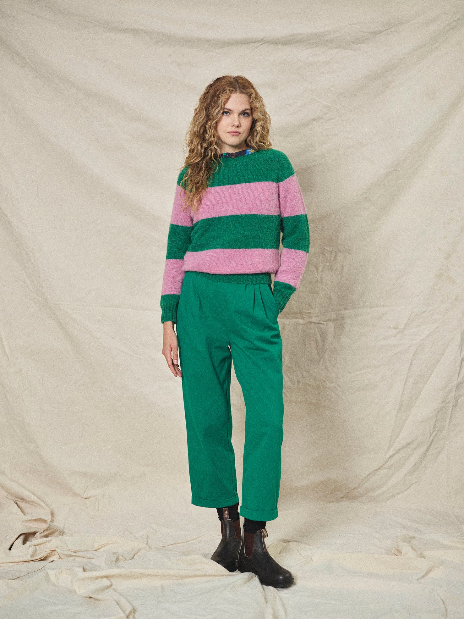 A pair of green pleat front trousers with a tab front opening and back jet pockets.
