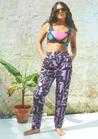 Full-length purple and black scribble print trousers with a high-rise fit and elasticated waistband, including pockets.