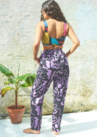 Full-length purple and black scribble print trousers with a high-rise fit and elasticated waistband, including pockets.