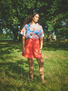 A pair of high-waisted, mid-length, tailored tomato shorts made from a cotton and linen mix.