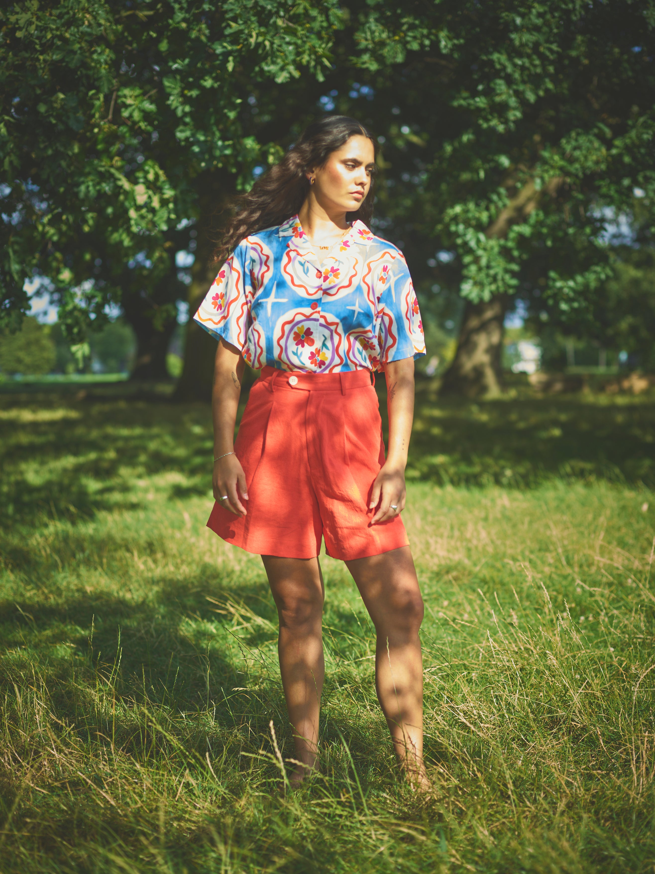 A pair of high-waisted, mid-length, tailored tomato shorts made from a cotton and linen mix.