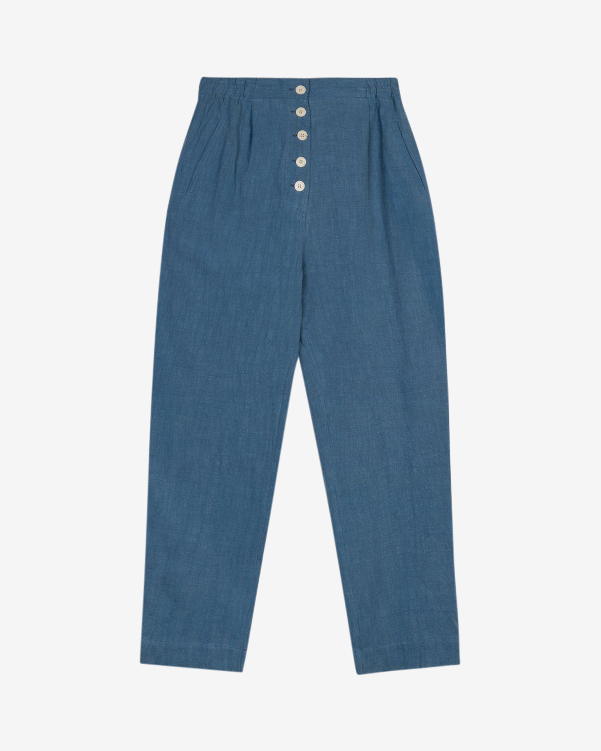 Washed blue cotton linen trousers with side welt pockets and elasticated waist at the back, featuring five corozo buttons down the front.
