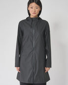 Woman wearing a black raincoat on a white background