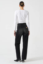 Person wearing black pants and a white long-sleeve shirt on a white background