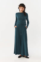 Woman wearing a teal outfit on a white background