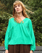 A vibrant grass green, voluminous statement top with a V-neckline and 3/4 length sleeves.