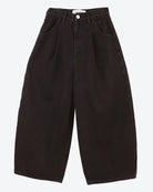 Ankle-length balloon-shaped black jeans with a high waist and pleats, featuring matte silver rivet detailing on the pockets.