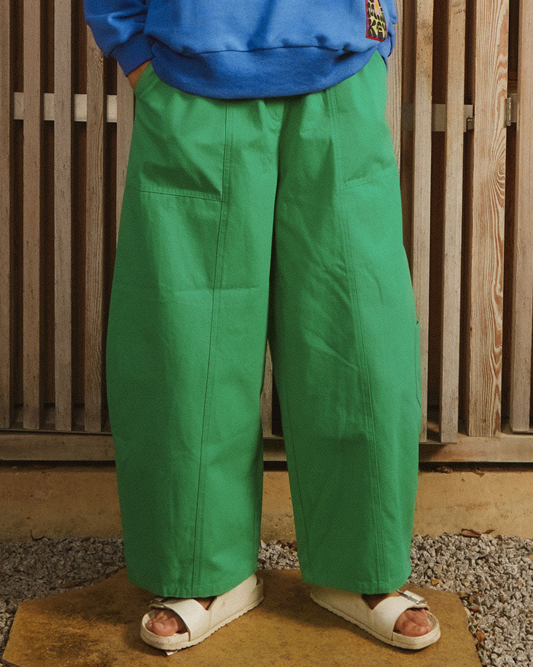 A pair of green cotton workwear style trousers with high elasticated waist and utility style pocket detailing.