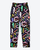 A pair of black holiday trousers with a multicolored scribble print, featuring a high waist, tapered leg, and side pockets.