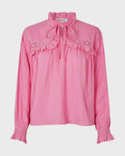 Pink blouse with lace details on a light gray background