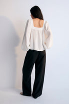 A white Tencel blouse with a square neckline, long sleeves, and elastic cuffs on a plain background.