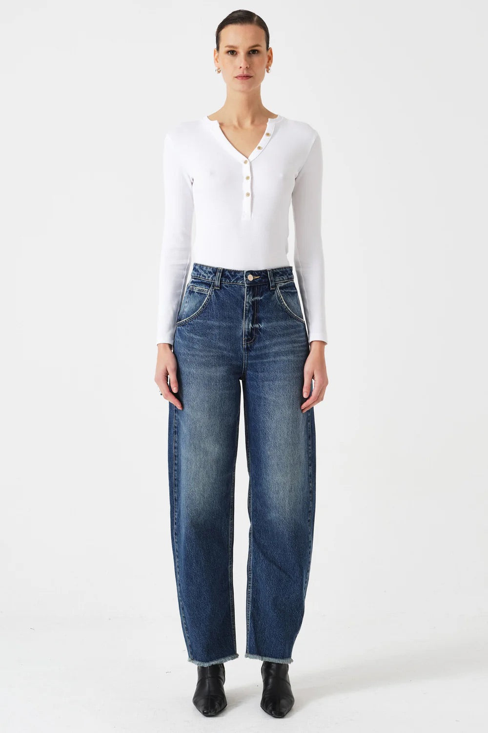 Person wearing a white shirt and blue jeans on a white background