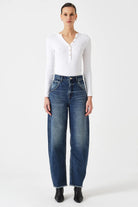 Person wearing a white shirt and blue jeans on a white background