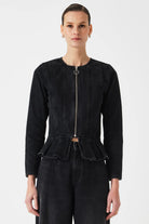 Person wearing a black peplum jacket on a white background