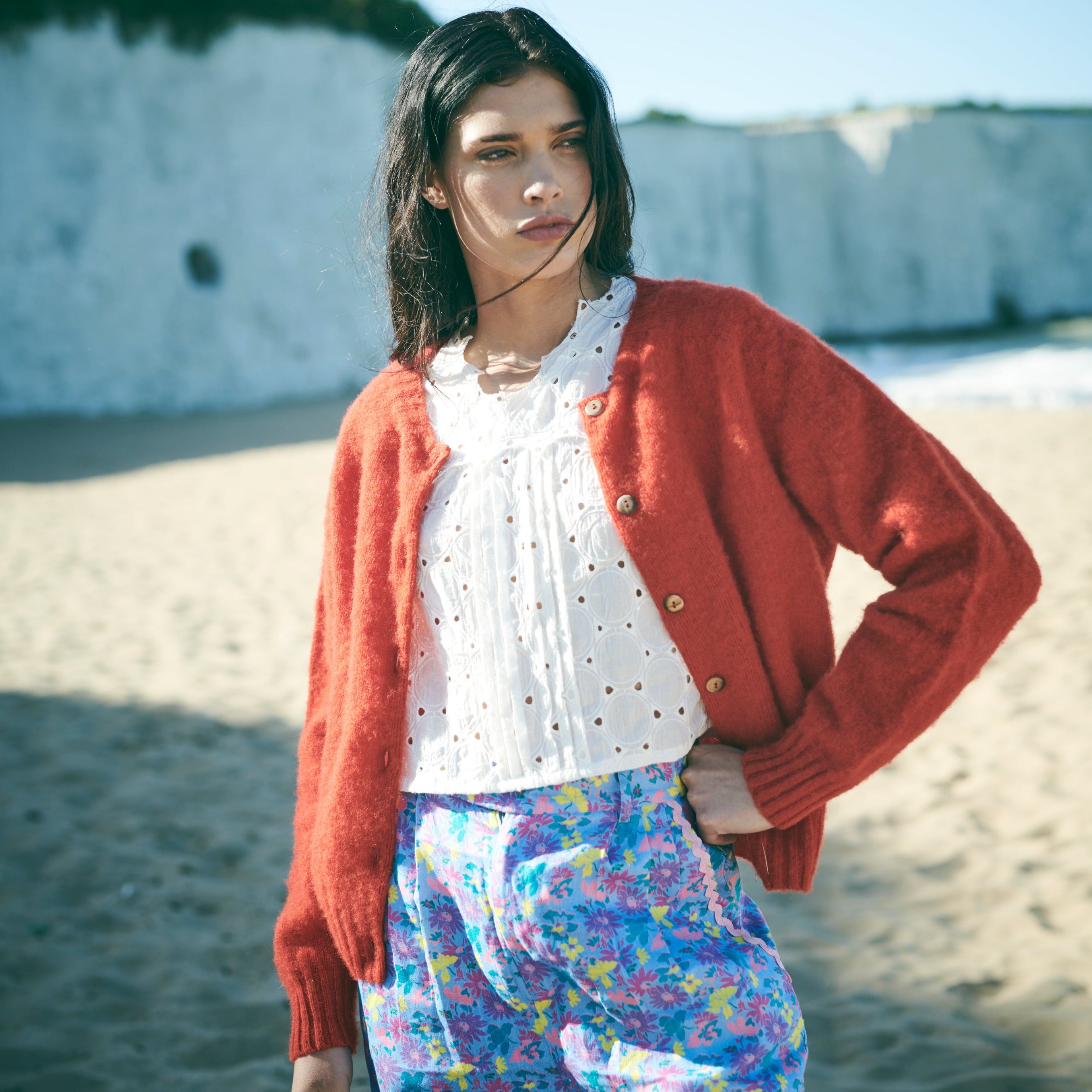 Red cardigan with button details on a white background