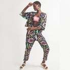 A pair of black holiday trousers with a multicolored scribble print, featuring a high waist, tapered leg, and side pockets.